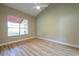 Sunny bedroom featuring wood-look floors, neutral walls and a large window at 2105 Clover Hill Rd, Palm Harbor, FL 34683