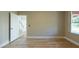 Spacious bedroom featuring wood-look floors and neutral walls with a doorway to the hall at 2105 Clover Hill Rd, Palm Harbor, FL 34683