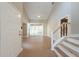 Bright, open entryway featuring tile flooring and a staircase with wood railings at 2105 Clover Hill Rd, Palm Harbor, FL 34683