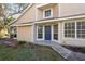 Front entrance of a well-maintained home with blue front door and covered porch at 2105 Clover Hill Rd, Palm Harbor, FL 34683