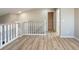 Hallway with wood-style floors leading to a doorway and staircase at 2105 Clover Hill Rd, Palm Harbor, FL 34683