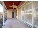 Screened patio with tile flooring, ceiling fan, and sliding glass doors at 2105 Clover Hill Rd, Palm Harbor, FL 34683