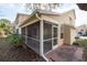 Exterior view showcasing the screened-in patio with access from the home with a tiled walkway at 2105 Clover Hill Rd, Palm Harbor, FL 34683