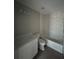 Full bathroom with white marble tiled tub and shower and white vanity at 2222 E Emma Street, Tampa, FL 33610