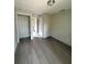 Bedroom with gray walls and dark floors featuring a closet and view to the hall at 2222 E Emma Street, Tampa, FL 33610
