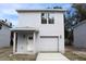 Two-story home featuring a garage, white door, and a modern, gray stucco exterior at 2222 E Emma Street, Tampa, FL 33610