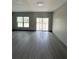 A spacious room with gray walls and flooring and a large window and glass sliding door at 2222 E Emma Street, Tampa, FL 33610