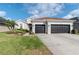 Charming home featuring a well-manicured lawn, a two-car garage and mature landscaping at 27045 Firebush Dr, Wesley Chapel, FL 33544