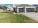 Charming home featuring a well-manicured lawn, a two-car garage and mature landscaping at 27045 Firebush Dr, Wesley Chapel, FL 33544