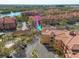 Aerial view of a condo community surrounded by lush landscaping and parking areas, near a lake at 2722 Via Tivoli # 430A, Clearwater, FL 33764