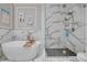 Elegant bathroom features a soaking tub and glass-enclosed shower with marble-style tile and modern fixtures at 2722 Via Tivoli # 430A, Clearwater, FL 33764