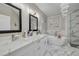 Well-lit bathroom with grey wood floors, a marble soaking tub, and double sinks at 2722 Via Tivoli # 430A, Clearwater, FL 33764