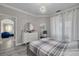 Well-lit bedroom with grey wood floors, a decorative light fixture, and a dresser at 2722 Via Tivoli # 430A, Clearwater, FL 33764