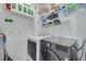 Well-organized laundry room with washer, dryer, and shelving, maximizing efficiency and storage in a compact space at 2722 Via Tivoli # 430A, Clearwater, FL 33764