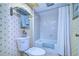 Compact bathroom featuring white fixtures and palm-tree wallpaper at 29230 Bay Hollow Dr # 3274, Wesley Chapel, FL 33543