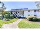 Two-story condominium complex with a walkway, black railings, and manicured landscaping at 29230 Bay Hollow Dr # 3274, Wesley Chapel, FL 33543