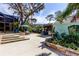 Well maintained backyard featuring a concrete patio, outdoor kitchen, screen enclosed lanai, and mature landscaping at 3089 Enisglen Dr, Palm Harbor, FL 34683