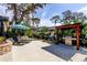 Spacious backyard with concrete patio, seating area with umbrella, and outdoor kitchen area at 3089 Enisglen Dr, Palm Harbor, FL 34683