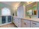 Bright bathroom featuring dual sinks, white cabinetry, and natural light at 3089 Enisglen Dr, Palm Harbor, FL 34683