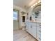 Bathroom featuring a vanity with a white countertop, a round mirror, and decorative wall art at 3089 Enisglen Dr, Palm Harbor, FL 34683