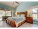 Airy bedroom featuring wood furnishings, access to the lanai, and plenty of natural light at 3089 Enisglen Dr, Palm Harbor, FL 34683