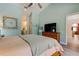 Tranquil bedroom boasting a ceiling fan, ensuite bath, and wood-look floors at 3089 Enisglen Dr, Palm Harbor, FL 34683