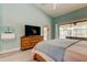Serene bedroom with ceiling fan, dresser, and access to the outdoor lanai and pool at 3089 Enisglen Dr, Palm Harbor, FL 34683