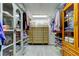 Walk-in closet with custom shelving, drawers, hanging rods, and light wood-look flooring at 3089 Enisglen Dr, Palm Harbor, FL 34683
