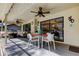 Relaxing covered patio featuring ceiling fans, a dining area, and comfortable seating with a view of the pool at 3089 Enisglen Dr, Palm Harbor, FL 34683