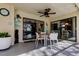 Covered patio featuring a dining area with white table and chairs, an outdoor clock, and views of the pool and backyard at 3089 Enisglen Dr, Palm Harbor, FL 34683