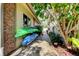 Side of house featuring brick paver path and lush landscaping with kayaks racked on wall at 3089 Enisglen Dr, Palm Harbor, FL 34683