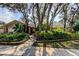 Landscaped walkway leads to a charming home with lush greenery and curb appeal at 3089 Enisglen Dr, Palm Harbor, FL 34683