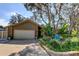 Inviting front yard with lush landscaping complementing this charming brick and siding home at 3089 Enisglen Dr, Palm Harbor, FL 34683