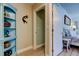 Hallway between bedroom and doorway featuring blue decorative shelving at 3089 Enisglen Dr, Palm Harbor, FL 34683