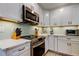 Updated kitchen featuring stainless steel appliances, marble counters, and light gray cabinets at 3089 Enisglen Dr, Palm Harbor, FL 34683