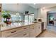 Bright kitchen featuring a large window, a kitchen island, and white cabinetry with modern hardware at 3089 Enisglen Dr, Palm Harbor, FL 34683