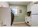 Laundry room with washer, dryer, window, cabinets and built-in pet house at 3089 Enisglen Dr, Palm Harbor, FL 34683