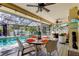 Covered patio with dining, multiple seating areas, and a swimming pool at 3089 Enisglen Dr, Palm Harbor, FL 34683
