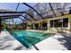 Sparkling pool with a screened enclosure, beautiful landscaping, and easy access to the covered outdoor living spaces at 3089 Enisglen Dr, Palm Harbor, FL 34683
