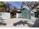 Exterior view of backyard shed with double doors and a white fenced-in yard at 3089 Enisglen Dr, Palm Harbor, FL 34683