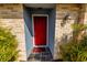 Inviting front entrance featuring a red door, brick accents, and decorative plants at 3298 Buckhorn Dr, Clearwater, FL 33761