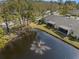 Aerial view features a tranquil pond with fountain and the home's screened lanai at 3401 Killdeer Pl, Palm Harbor, FL 34685