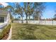 Expansive backyard features a well-maintained lawn, mature trees, and a pristine white privacy fence at 3401 Killdeer Pl, Palm Harbor, FL 34685