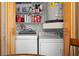 The laundry room features washer, dryer, shelving, and wood cabinets for storage at 3401 Killdeer Pl, Palm Harbor, FL 34685