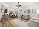 Bright and airy living room with hardwood floors, modern furniture, and an open floor plan leading to the dining area at 3401 Killdeer Pl, Palm Harbor, FL 34685
