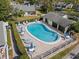 Aerial view of community pool and lounge area, complete with ample seating, umbrellas, and manicured hedges at 3401 Killdeer Pl, Palm Harbor, FL 34685