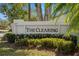 Community sign for 'The Clearing' with manicured landscaping, set against a backdrop of trees at 3401 Killdeer Pl, Palm Harbor, FL 34685