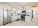 Galley kitchen features white cabinets, stainless steel appliances, and stylish countertop at 37321 8Th Ave, Zephyrhills, FL 33542