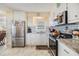 Galley kitchen features white cabinets, stainless steel appliances, and stylish countertop at 37321 8Th Ave, Zephyrhills, FL 33542
