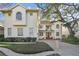Two-story home with brick driveway, manicured lawn, and a large tree on a sunny day at 4610 W Browning Ave, Tampa, FL 33629